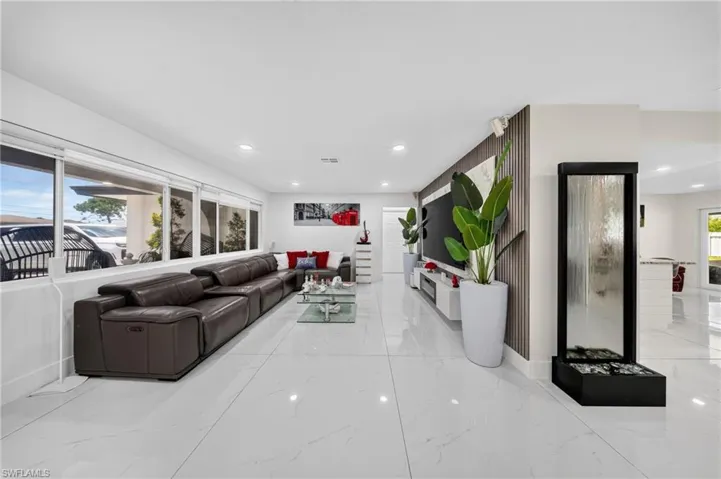 White tile flooring, recessed lighting, and a contemporary wall feature with vertical wood paneling