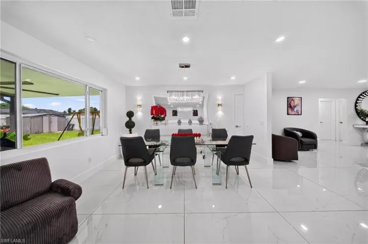Spacious dining area featuring large windows, recessed ceiling lighting, and reflective tile flooring