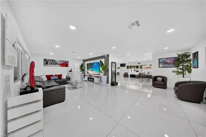 Spacious interior with large format white tile flooring, recessed lighting, and expansive windows