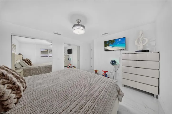 White tile flooring, overhead drum light fixture, and mirrored closet doors