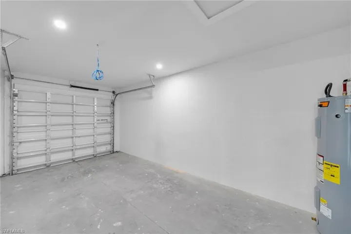 Single-car garage featuring a roll-up door, concrete flooring, and recessed ceiling lighting