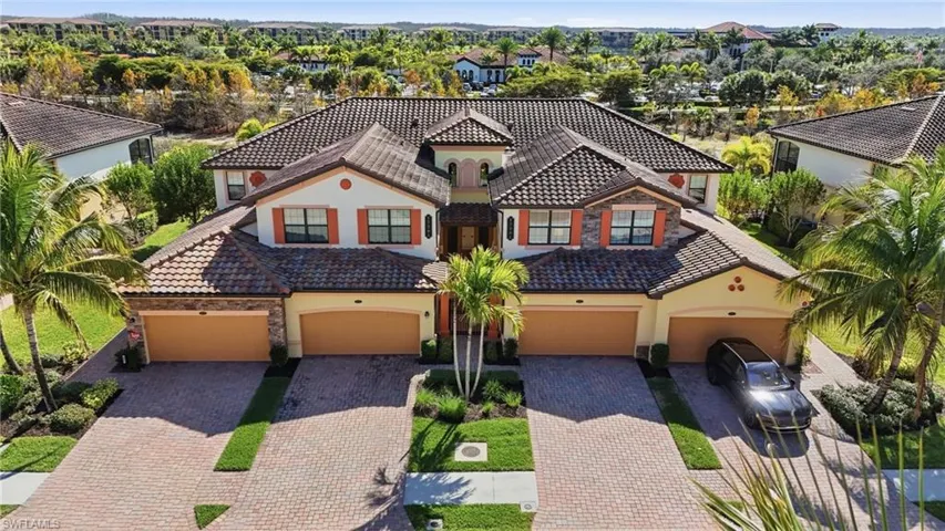 Aerial of Coach home condo 2nd floor, featuring stone & stucco siding, entry gate, and decorative driveway