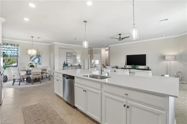 Elegant open kitchen with white cabinets, quartz countertops, and a generous island designed for effortless flow into the dining and living areas.