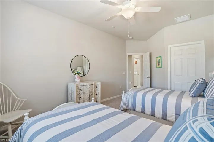 Charming guest bedroom featuring plantation shutters and coastal-inspired décor.