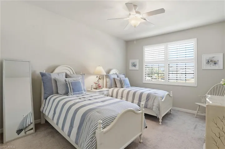 Guest bedroom tastefully designed with plantation shutters and a relaxed beach vibe.