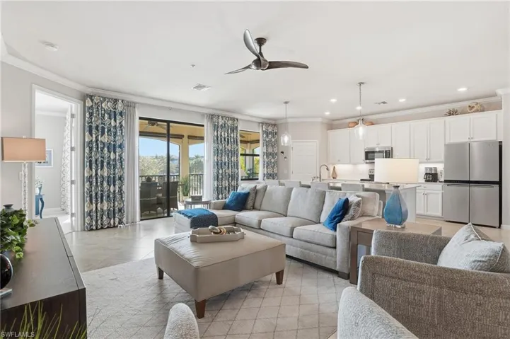 Inviting open-concept living area highlighted by crown molding, recessed lighting, a modern ceiling fan, tasteful drapes, and a modern kitchen.