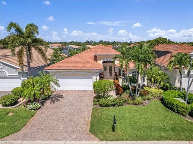 Mediterranean / spanish-style home with a garage and a front lawn