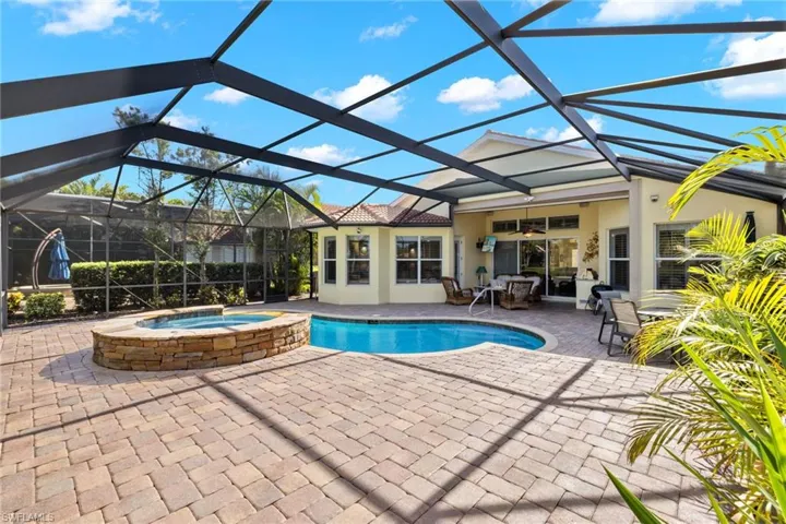 View of swimming pool with an in ground hot tub, a lanai, and a patio area