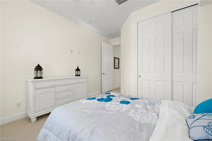 Carpeted bedroom with a closet