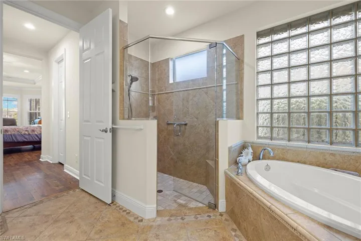 Bathroom featuring hardwood / wood-style flooring and shower with separate bathtub