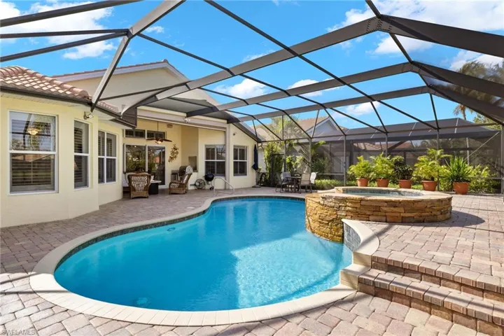 View of swimming pool with a patio, an in ground hot tub, and a lanai