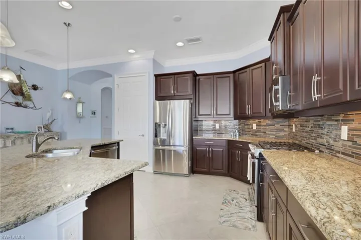 Kitchen has granite countertops and tiled backsplash