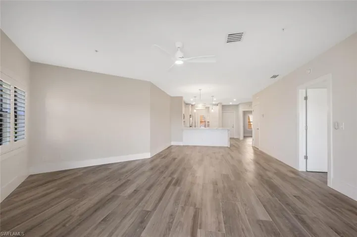 Unfurnished living room featuring hardwood / wood-style flooring and ceiling fan