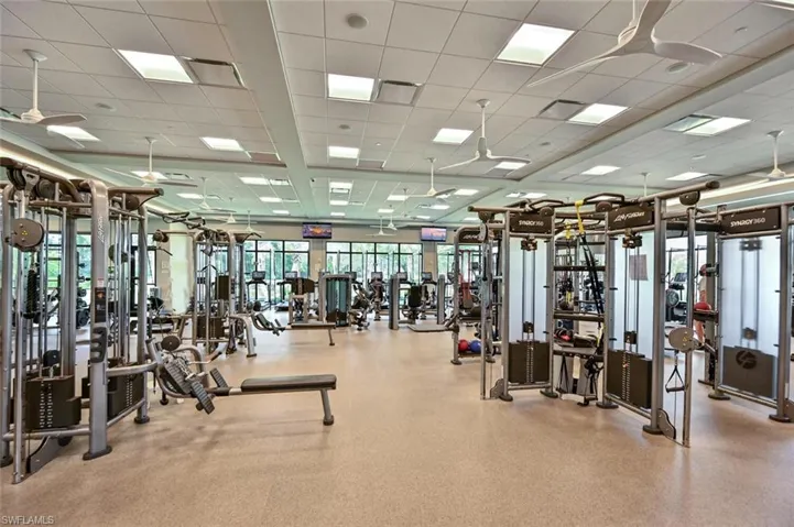 Gym with a paneled ceiling and ceiling fan