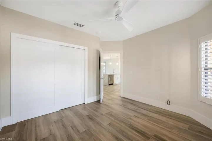 Unfurnished bedroom with hardwood / wood-style floors, ceiling fan, and a closet