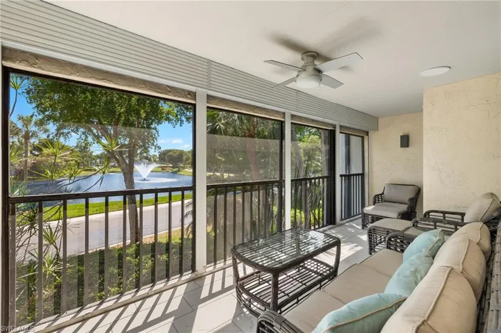 Sunroom / solarium with ceiling fan and a water view
