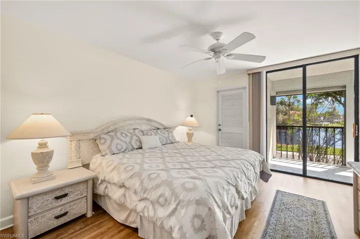 Bedroom featuring floor to ceiling windows, wood finished floors, ceiling fan, and access to outside