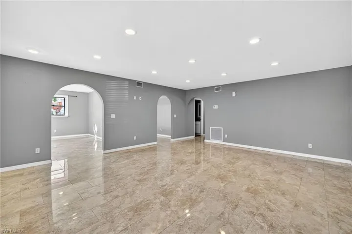 Unfurnished room featuring recessed lighting and arched walkways
