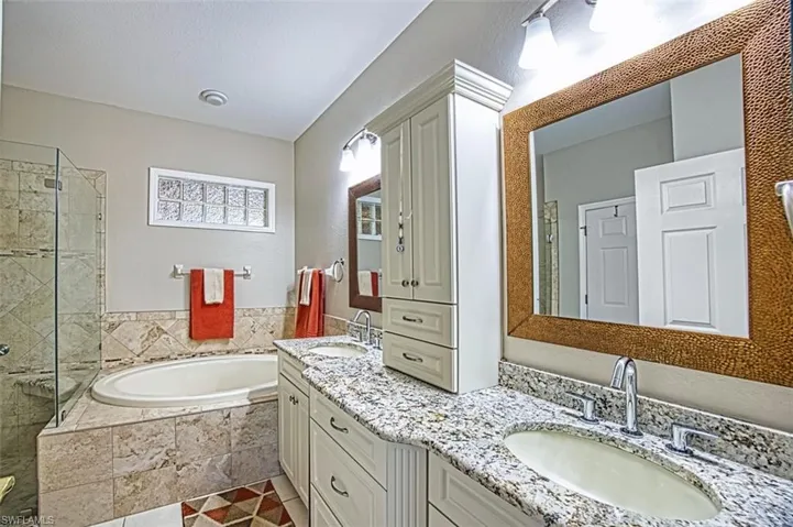 Full bathroom featuring a garden tub, a shower stall, vanity, and light tile patterned flooring