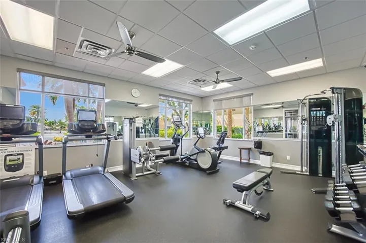 Exercise room with a ceiling fan and a paneled ceiling