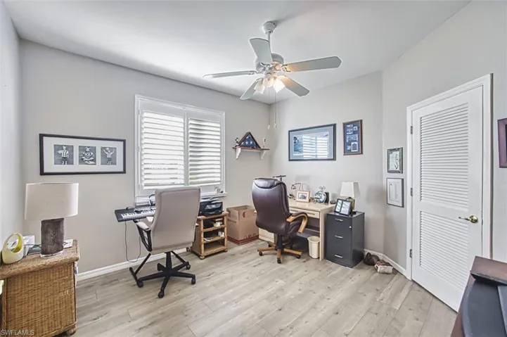 Home office with a ceiling fan and light wood-style floors