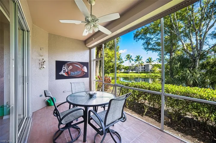 Sunroom with ceiling fan and a water view