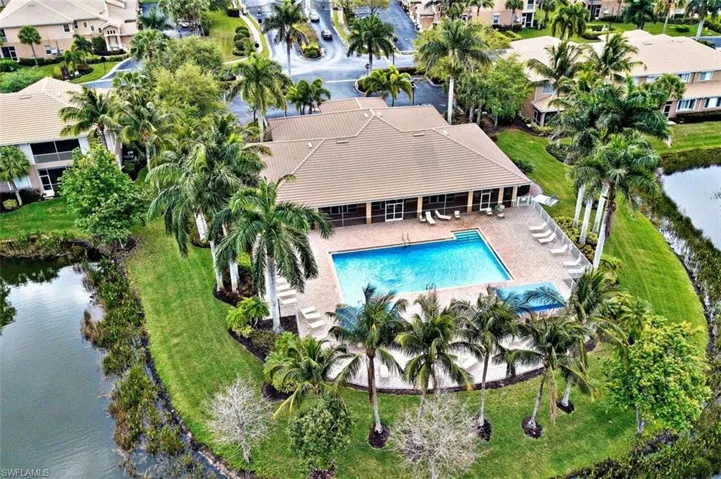 Aerial perspective of suburban area with a pool area and a nearby body of water