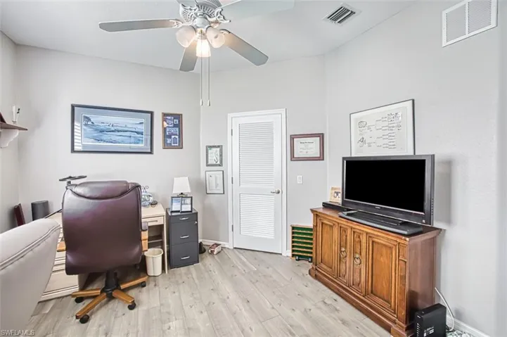 Office space with light wood-style flooring and a ceiling fan