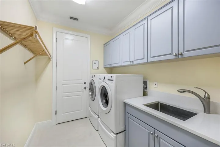 Spacious laundry room with extra cabinets and shelving