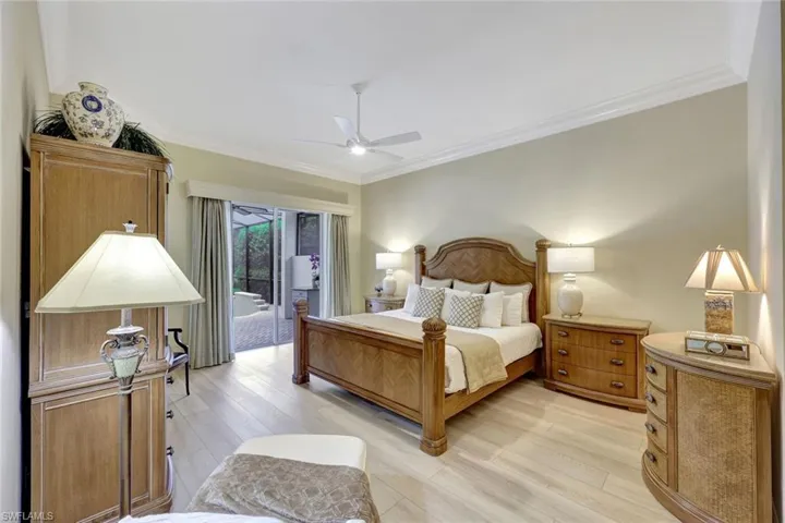 Large primary bedroom with plantation shutters and neutral LVP flooring