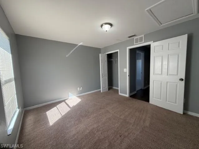 Unfurnished bedroom with a closet and dark colored carpet