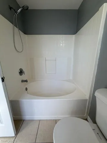Bathroom featuring light tile patterned floors and shower / tub combination