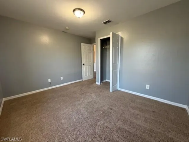Unfurnished bedroom featuring carpet flooring and a closet