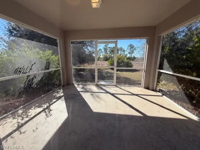 Unfurnished sunroom with concrete floors