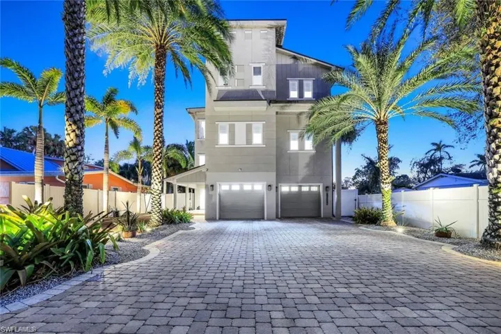 View of front of property featuring decorative driveway, a garage, and stucco siding