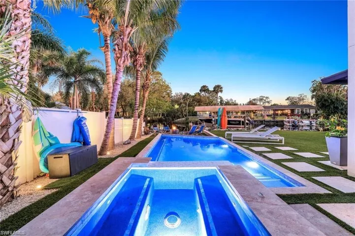 View of pool featuring a patio, a fenced backyard, and a pool with connected hot tub