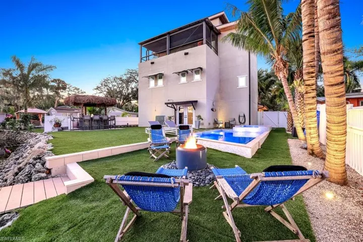 Back of property featuring a patio area, a fenced backyard, a balcony, an outdoor fire pit, and stucco siding