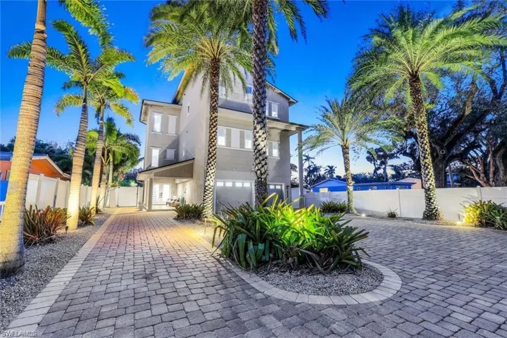View of front of property featuring a balcony, stucco siding, and decorative driveway