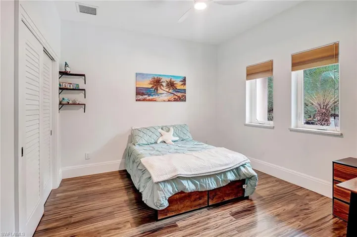Bedroom with wood finished floors, a closet, and a ceiling fan