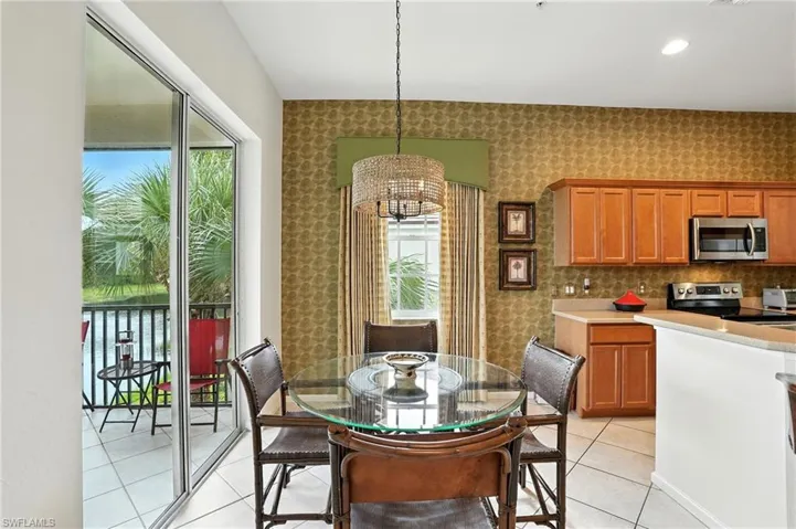 Dining space with a chandelier, light tile patterned floors, recessed lighting, and wallpapered walls