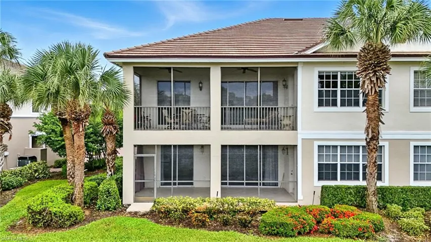 Rear view of house with a balcony, stucco siding, a sunroom, a ceiling fan, and a tile roof