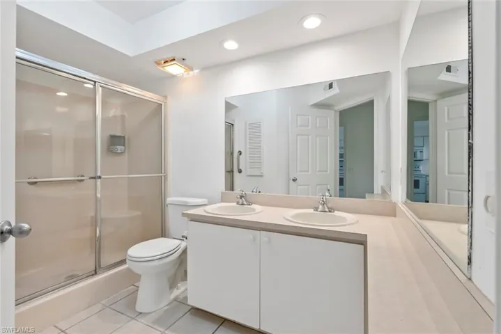 Master bath with tile patterned flooring, vanity, toilet, and an enclosed shower