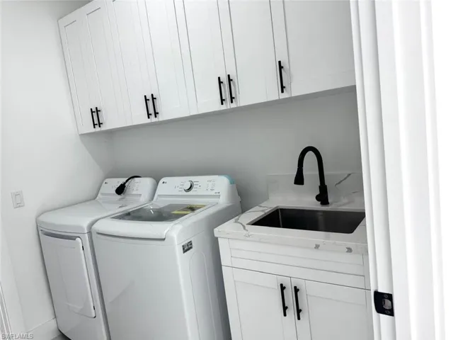 Laundry area featuring washing machine and dryer and cabinet space