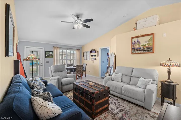 Tiled living room featuring vaulted ceiling and ceiling fan