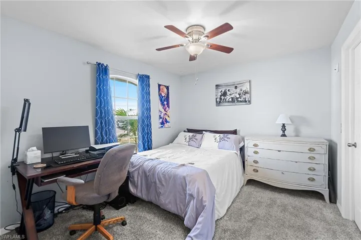 Carpeted bedroom featuring ceiling fan