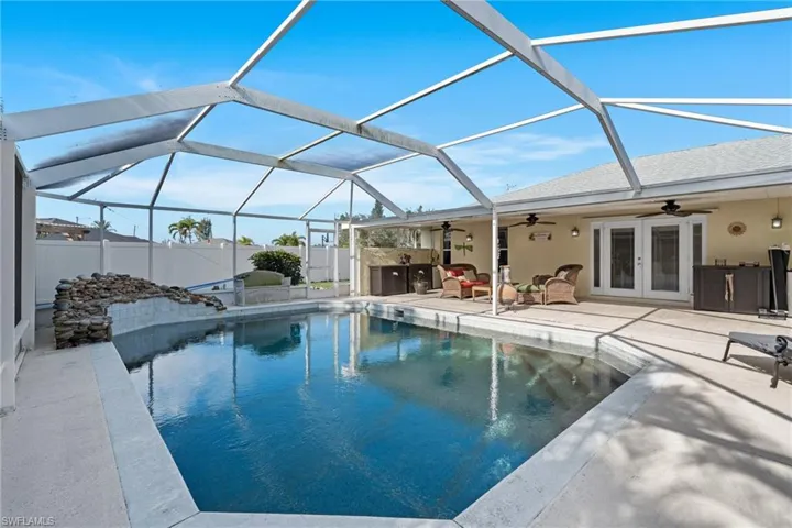View of swimming pool with french doors, ceiling fan, a lanai, and a patio