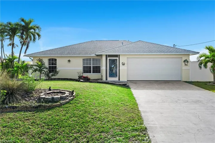 Single story home with a garage and a front yard