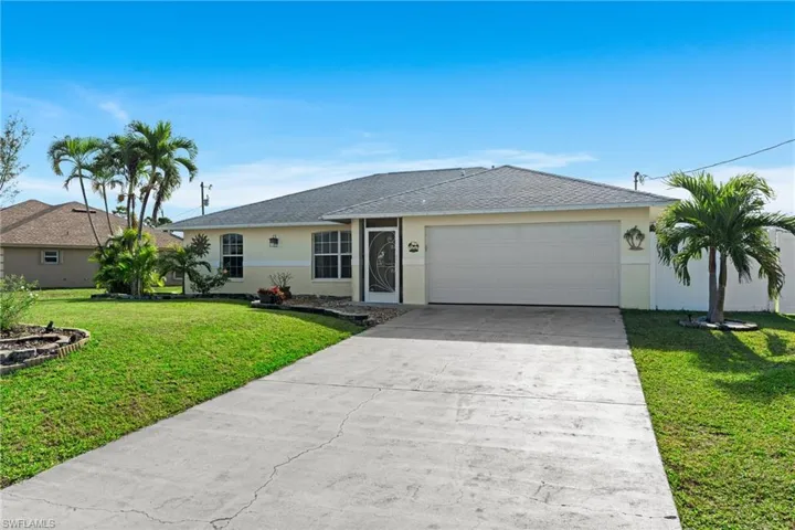 Ranch-style house featuring a garage and a front lawn