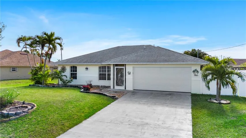 Single story home featuring a garage and a front yard