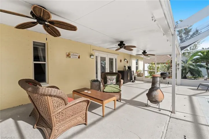 View of patio / terrace with area for grilling, french doors, ceiling fan, and glass enclosure